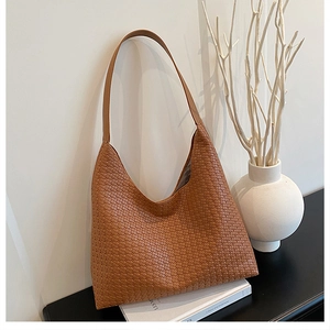 Detail of brown woven hobo shoulder bag with textured checkerboard pattern finish