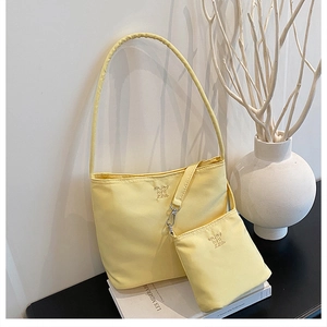 Close-up of pale yellow nylon hobo bag set with fine embroidery and small pouch