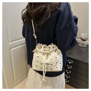 Détail du sac seau blanc avec anse en perles, nœuds et fermeture à cordon