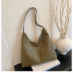 Detailed view of olive green woven leather hobo bag texture and minimalist shoulder strap