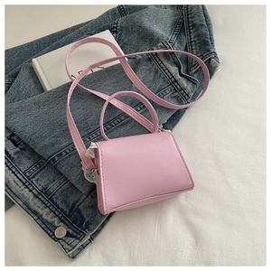 Close-up of pink crossbody bag side featuring delicate white lace embroidery details