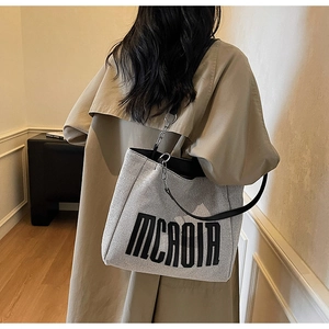 Fashionable large tote bag in grey textured fabric showing real-life size on model