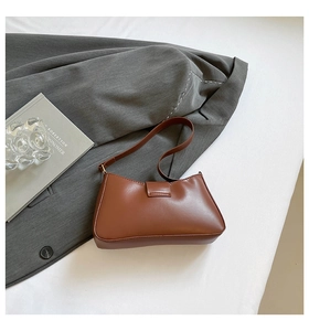Detail view of coffee brown faux leather shoulder bag with magnetic flap closure
