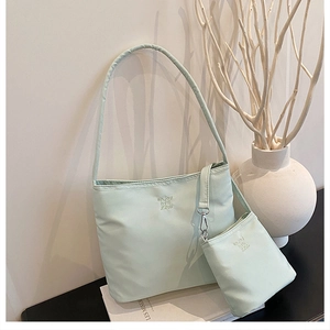 Close-up of light green nylon shoulder bag with letter embroidery and coin purse set