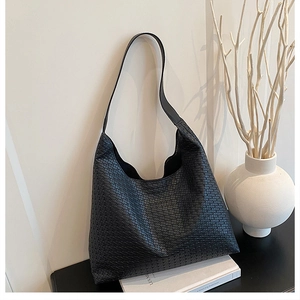 Detailed close-up of a black woven leather hobo bag featuring premium texture and wide strap