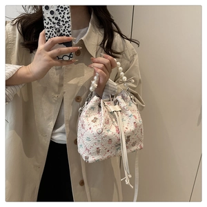 Détail d'un sac seau avec imprimés d'ours et poignée en perles élégante