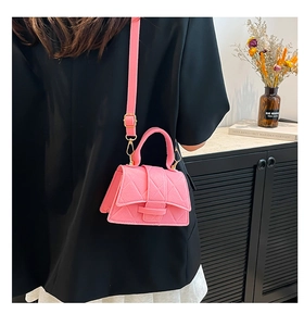 Pink quilted faux leather mini bag shown on a shoulder strap with chic buckle detail