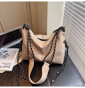 Dettaglio della borsa a tracolla in nylon beige con spallacci in corda intrecciata
