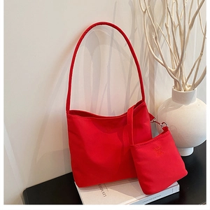 Detail of red nylon bucket tote bag with embossed letters and matching small coin purse