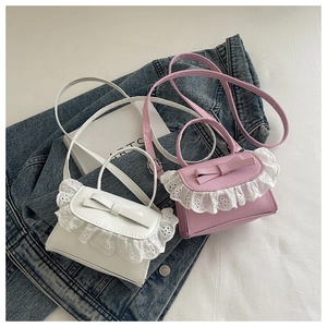 Dettaglio delle mini borse in ecopelle con bordo in pizzo e fiocco in bianco e rosa