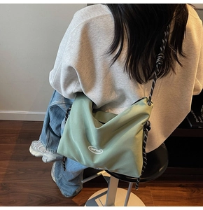 Dettaglio borsa a tracolla in nylon verde con tracolla a corda bicolore e logo GAIFYUN