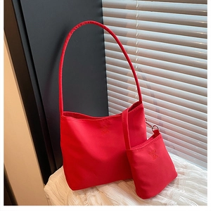 Macro shot of red nylon hobo bag set with matching small pouch and embossed lettering