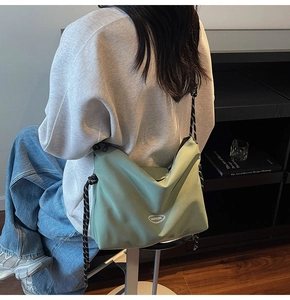 Dettaglio della borsa a tracolla in nylon verde chiaro con cinturino intrecciato bicolore