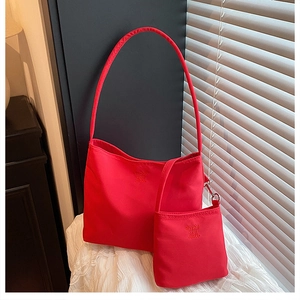 Detail of red nylon tote bag with enjoy zzc embroidery and matching mini zipper pouch
