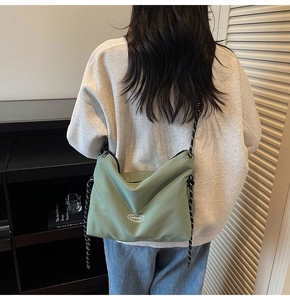 Dettaglio borsa a tracolla in nylon verde salvia con cinturino in corda intrecciata