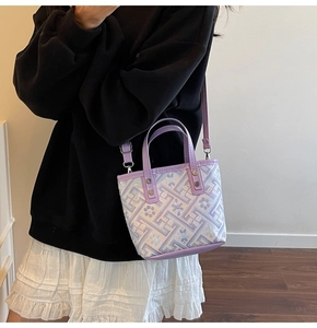 Detail of lavender floral embroidery and purple leather trim on a mini bucket bag