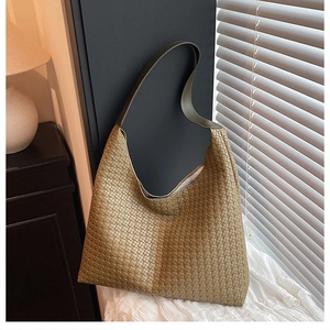 Close-up of olive green woven shoulder bag showing fine leather texture in natural light