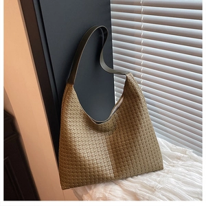 Close-up of woven leather texture on an olive green hobo bag with a luxury aesthetic