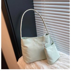 Detailed view of mint green nylon shoulder bag with matching coin purse and embroidery