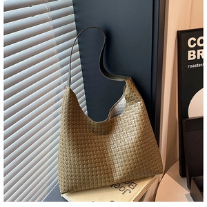 Detailed view of the olive green woven texture and premium strap on this hobo tote bag