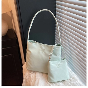 Detail view of mint green nylon bag with embossed enjoy life text and matching mini pouch