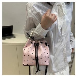 Détail d'un sac seau rose avec poignée en perles et motif de lapin noir mignon