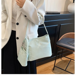 Detail view of light green nylon shoulder bag set with small matching coin pouch and logo