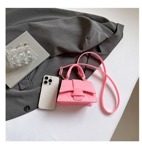 Detail of bright pink quilted felt crossbody bag with flap and top handle design