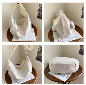 Detail view of white nylon crescent bag with mini round pouch and yellow fashion label