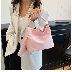 Pink nylon hobo shoulder bag and small matching pouch set shown on casual white suit