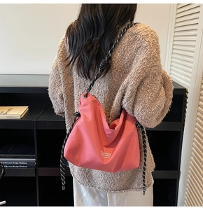 Pink nylon crossbody bag with chic black and white woven rope strap and brand logo