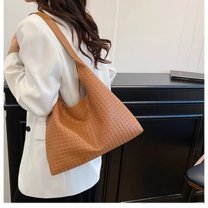 Detail of caramel brown woven hobo bag with large capacity and wide shoulder strap