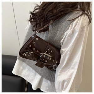Detailed side view of coffee brown patent leather bag with metal rivets and buckles