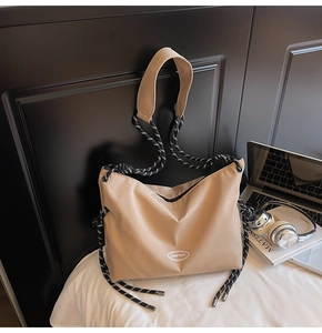 Dettaglio della borsa tote in nylon kaki con manici in corda intrecciata bianca e nera