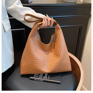 Close-up of the woven leather texture and elegant shoulder strap on this camel hobo bag