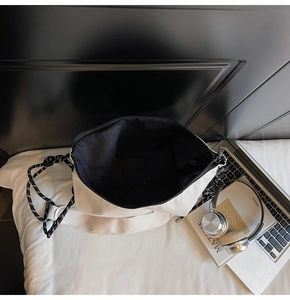 Vista interna della capiente borsa tote crema con fodera nera e tracolla a coulisse