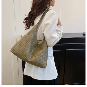 Detail of olive green woven leather tote bag texture and soft hobo shoulder strap