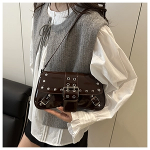 Détail du sac d'épaule en cuir verni marron foncé avec rivets et boucles en métal