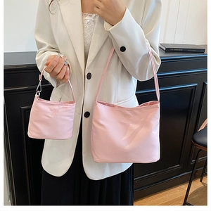 Detailed view of pink nylon bucket bag with ENJOY LIFE engraving and small coin pouch