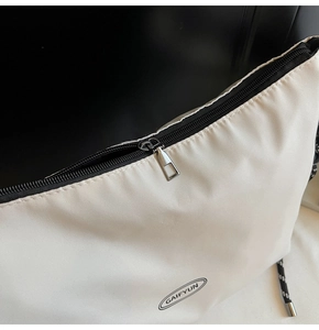 Dettaglio della borsa GAIFYUN in nylon beige con zip e trama del logo del brand