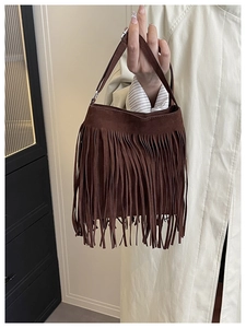 Close-up of deep brown suede-textured handbag featuring stylish bohemian fringe details