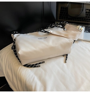 Dettaglio della borsa a tracolla in nylon bianco con tracolla in corda intrecciata