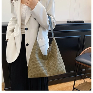 Detail of woven khaki leather texture on oversized slouchy hobo shoulder bag
