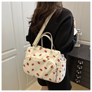 Detailed texture of corduroy crossbody bag featuring sweet strawberry prints and zipper pocket