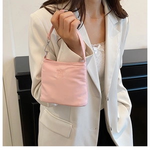 Detail of pink nylon bucket bag with enjoy by pizza embossed text and metal clip