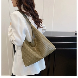 Detail of olive green woven leather hobo bag with classic Intrecciato texture for daily use