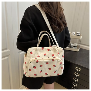Detail of strawberry corduroy tote bag with zipper pocket and canvas strap