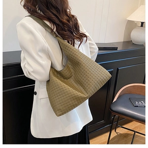 Olive green woven leather hobo bag styled with a white blazer and black dress