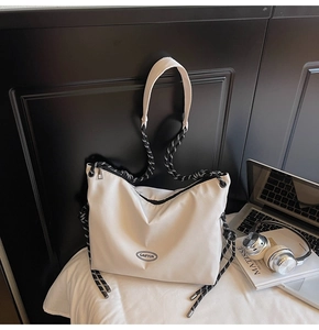 Dettaglio della borsa tote in nylon bianco con tracolla in corda intrecciata a righe bianche e nere