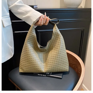 Detailed view of olive green woven hobo bag showing large capacity and leather texture